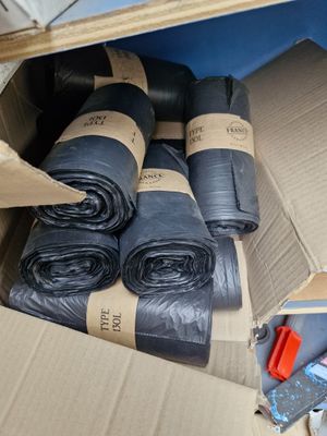 une boîte en carton contenant plusieurs rouleaux de plastique noir