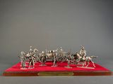 a silver figurine of a group of people on horses