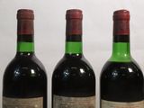 three bottles of wine are lined up in a row on a table