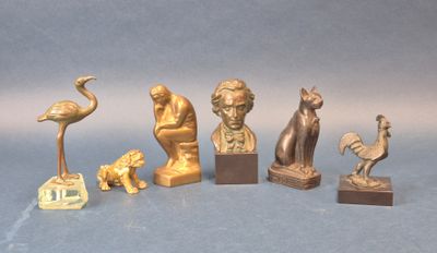 cinq statues en bronze représentant des animaux et des oiseaux, sur un fond bleu