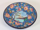a blue bowl with a picture of a tree on it