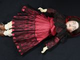 a doll that is laying down on a black surface
