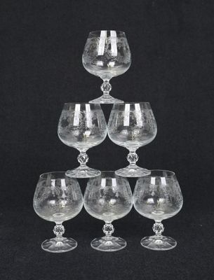 six verres à vin empilés les uns sur les autres sur un fond noir