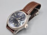 an image of a watch with a brown leather strap on a white surface
