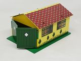 a small yellow house with a red roof and a green door