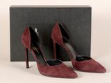 une paire d'escarpins en daim bordeaux, accompagnée d'un coffret noir