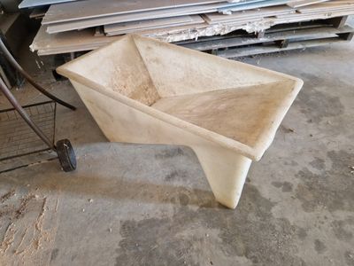 a wheelbarrow that is sitting on the floor next to a pile of wood