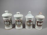 three white ceramic jars with decorative designs on them on a gray surface