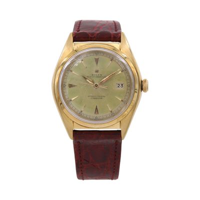 a gold watch with a green dial and brown leather strap