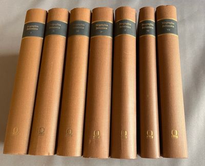 six livres à la couverture marron posés sur un drap blanc