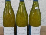 trois bouteilles de vin posées sur une table, l'une à côté de l'autre