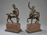 pair of bronze statues of a man on a horse and a woman on a horse