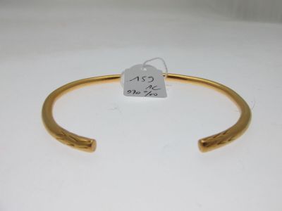 a close up of a gold bracelet with a tag on it