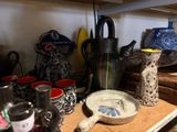many different types of pottery displayed on a shelf