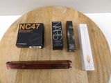 a wooden table with a box of makeup and a pen on it