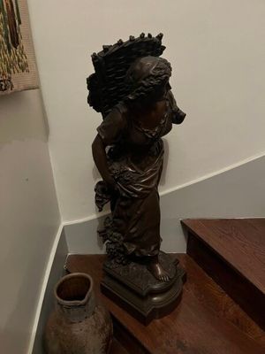 a statue of a woman on the stairs of a house