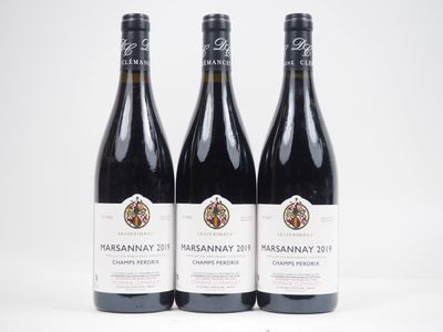 trois bouteilles de vin sont posées sur une surface blanche