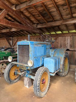 deux vieux tracteurs dans une grange au toit en bois