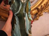 a person that is holding a statue in front of a mirror