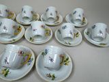 several cups and saucers are sitting on a white table