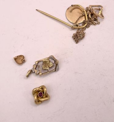 Plusieurs bijoux en or et en argent sont posés sur une surface blanche.