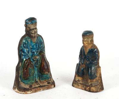 pair of ceramic figurines of a man and a woman sitting on a tree stump