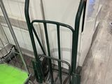 a green hand truck and a green shopping cart in a store