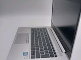 a silver laptop with a black keyboard on a white surface