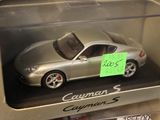 a silver toy car in a box with a sign on it