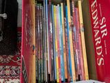 une boîte remplie de livres pour enfants posée par terre