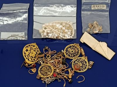 beaucoup de bijoux en or posés sur une table bleue