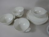 a lot of white dishes and cups on the table