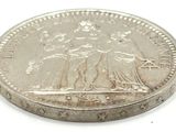an image of a silver coin on a white surface with a white background