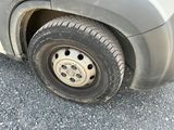 a dirty tire on the side of a truck