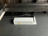 a white air conditioner sitting on the floor in a room