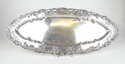 une assiette ancienne en argent, ornée d'un motif décoratif sur le bord
