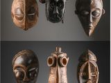 Plusieurs masques africains sont exposés sur un fond noir