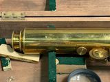 a brass telescope in a wooden box with a magnifying glass