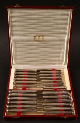 un coffret rouge contenant de l'argenterie, posé sur une surface noire