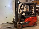 un chariot élévateur rouge garé dans un garage, à côté d'une porte de garage