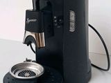 a coffee maker that is sitting next to a cup