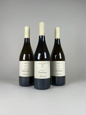 trois bouteilles de vin posées sur une table blanche