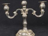 a silver metal candle holder on a black background