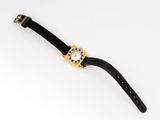 a close up of a watch on a white surface with a black strap