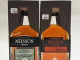 deux bouteilles de whisky posées dans une boîte sur une surface blanche