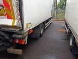 two trucks that are parked side by side on the street