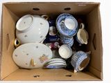 une boîte en carton remplie de vaisselle et de tasses de toutes sortes