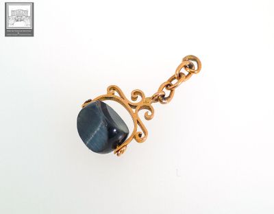 un gros plan d'un collier plaqué or orné d'une pierre bleue
