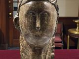 sculpture of a woman ' s head on a table in a room