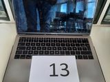un ordinateur portable posé sur une table sur laquelle figure le chiffre 13